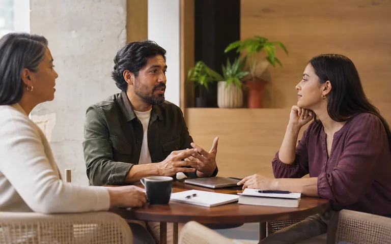 Dos profesionales conversan en un espacio de trabajo.